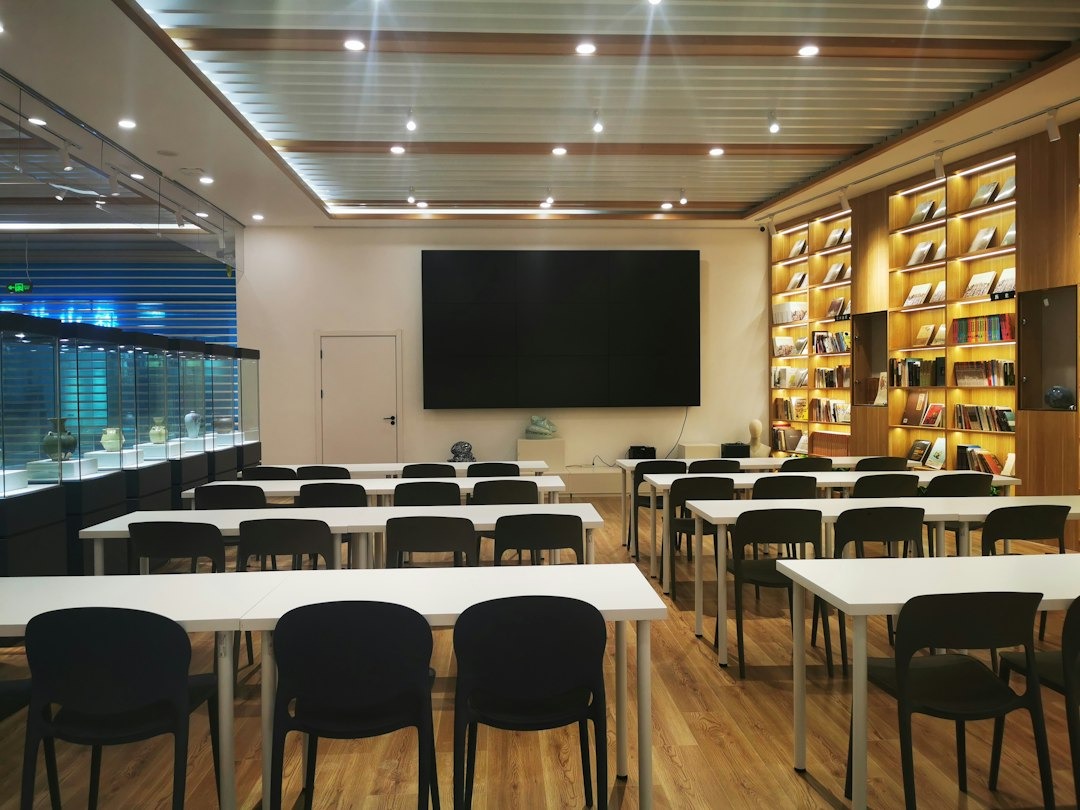 Aula di formazione con tavoli e sedute rivolti verso uno schermo
